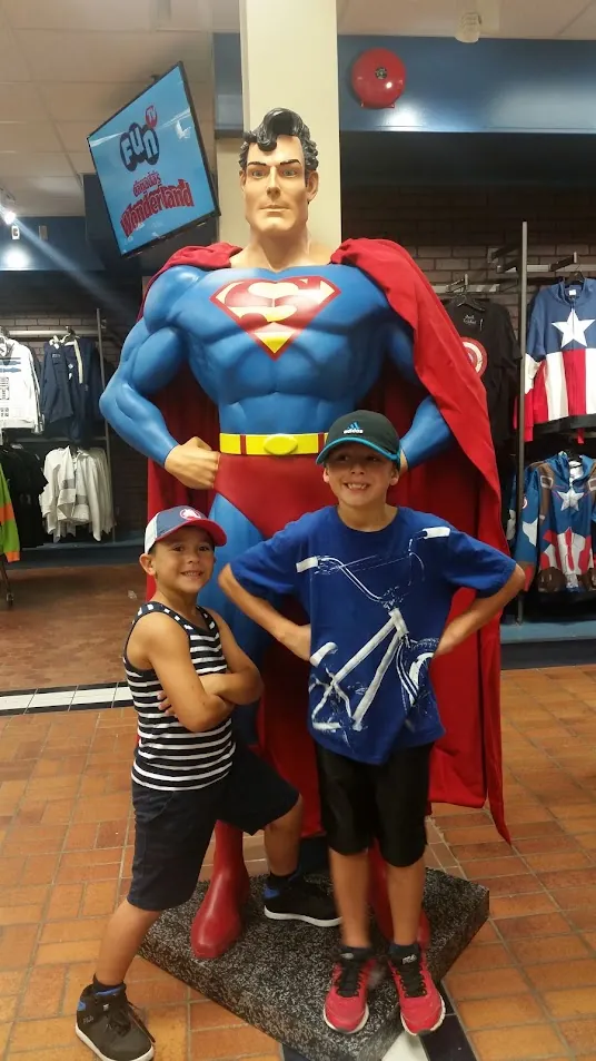 Two boys striking superhero poses at a photo op during an action-packed birthday party