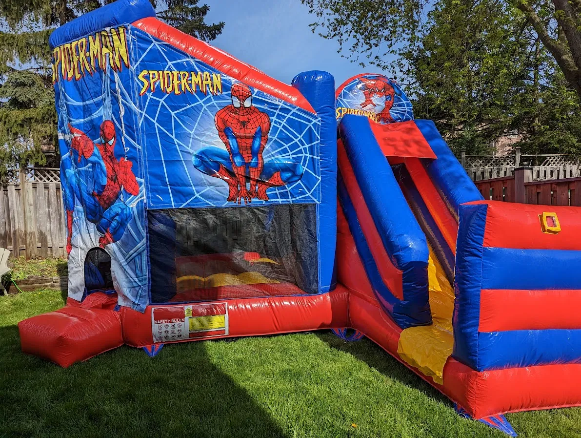 Spider-Man bouncy castle combo with slide set up on a green lawn for a boys birthday party in Mississauga